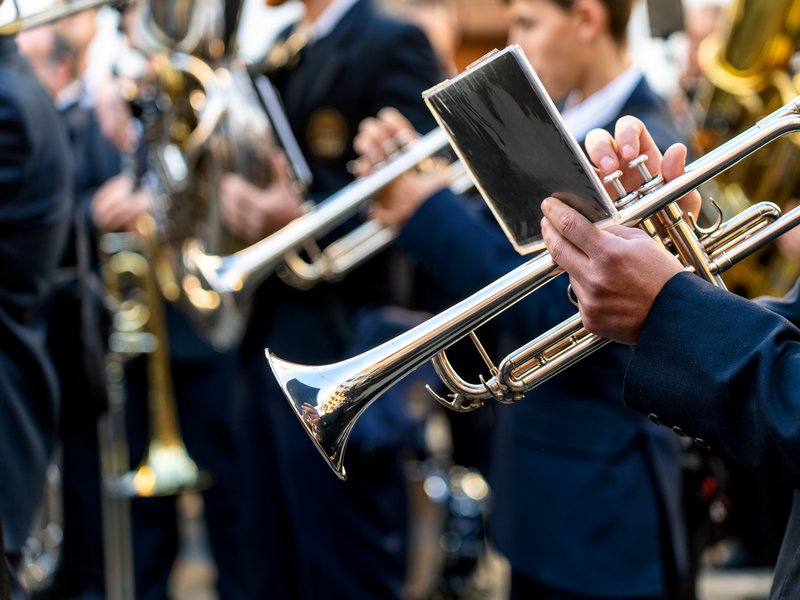 Band musicians in uniform playing trumpets together